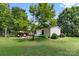 Well-maintained backyard with lush grass, landscaping, patio seating and a single story home at 125 Brasington Ln, Mooresville, NC 28115