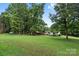 Spacious backyard featuring mature trees, lush grass, and a single story home at 125 Brasington Ln, Mooresville, NC 28115