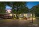 Evening view of a spacious backyard featuring a deck, patio seating, and a well-lit home at 125 Brasington Ln, Mooresville, NC 28115