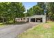 Single-story home with an open garage and a spacious paved driveway at 125 Brasington Ln, Mooresville, NC 28115
