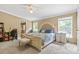 Comfortable main bedroom features a king bed, carpet flooring, natural light, and an ensuite bathroom at 125 Brasington Ln, Mooresville, NC 28115