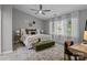 Bright bedroom with a tufted headboard, ceiling fan, and large windows offering ample natural light at 12524 Angel Oak Dr, Huntersville, NC 28078
