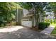 Attached two-car garage featuring white doors and a concrete driveway surrounded by mature trees at 12524 Angel Oak Dr, Huntersville, NC 28078