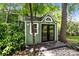 Charming green outbuilding with a unique horseshoe detail above the double glass paned doors at 12524 Angel Oak Dr, Huntersville, NC 28078