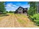 Beautiful backyard features lush landscaping, a well-maintained lawn, and a modern home design with a large back porch at 130 Broken Arrow Dr, Statesville, NC 28677