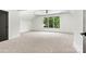 Spacious bedroom features a large window with lush greenery views, and neutral carpet at 130 Broken Arrow Dr, Statesville, NC 28677