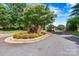 Welcoming entrance to River Oaks at Lake Norman, featuring mature trees and manicured landscaping at 130 Broken Arrow Dr, Statesville, NC 28677
