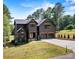 Striking two-story home with a modern design, dark exterior, three gables, and a well-manicured lawn at 130 Broken Arrow Dr, Statesville, NC 28677