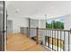 Bright upstairs hallway with hardwood floors, black metal railing, and accent wall at 130 Broken Arrow Dr, Statesville, NC 28677