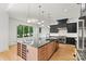 Bright kitchen with island, stainless appliances, and large windows providing ample natural light and view of the yard at 130 Broken Arrow Dr, Statesville, NC 28677