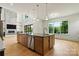 Bright, modern kitchen with an island featuring dual sinks, stainless steel dishwasher, and views of the yard at 130 Broken Arrow Dr, Statesville, NC 28677