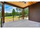 Covered patio with wood ceiling and metal railing overlooking golf course and backyard at 130 Broken Arrow Dr, Statesville, NC 28677