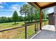 Covered patio with metal railing overlooking golf course and backyard at 130 Broken Arrow Dr, Statesville, NC 28677