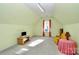 A bonus room is brightly lit and has red curtains and yellow furniture at 13247 Eastfield Village Ln, Charlotte, NC 28269