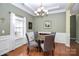 Dining area with hardwood floors, large window, and stylish chandelier at 13247 Eastfield Village Ln, Charlotte, NC 28269