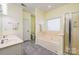 This bathroom features a double vanity, soaking tub and walk in shower with bright natural lighting at 13402 Mccoy Rd, Huntersville, NC 28078