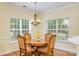 Close up of dining room with chandelier, dining table, and natural light from the two windows with outside views at 13402 Mccoy Rd, Huntersville, NC 28078