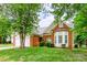 Traditional brick home with manicured lawn, mature trees, and attached two-car garage at 13402 Mccoy Rd, Huntersville, NC 28078