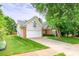 Home exterior featuring brick and siding, attached garage, and well-maintained lawn at 13402 Mccoy Rd, Huntersville, NC 28078