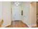 View of the foyer with wood floors, white trim, front door and coat closet at 13402 Mccoy Rd, Huntersville, NC 28078