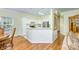 Open kitchen featuring white cabinets, stainless steel appliances, an island with eat-in bar, and hardwood flooring at 13402 Mccoy Rd, Huntersville, NC 28078