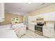 Open kitchen with white cabinets, island bar, stainless steel appliances, and sightlines into the dining area at 13402 Mccoy Rd, Huntersville, NC 28078