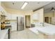 Spacious kitchen with stainless steel refrigerator, white cabinets, and stylish tile flooring at 13402 Mccoy Rd, Huntersville, NC 28078