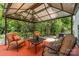 Covered back patio with comfortable seating surrounded by a lush garden at 13622 Stringfellow Ln, Charlotte, NC 28278
