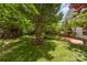 Spacious backyard with a beautiful shade tree and a patio with seating at 13622 Stringfellow Ln, Charlotte, NC 28278
