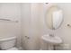 Compact bathroom with a pedestal sink, toilet, and neutral color scheme at 13622 Stringfellow Ln, Charlotte, NC 28278