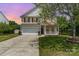 Traditional two-story home with a two car garage, front porch, and manicured lawn at 13622 Stringfellow Ln, Charlotte, NC 28278