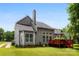 A well-maintained backyard featuring lush green grass, mature trees, and a wooden deck with stairs at 13832 Queenswater Ln, Charlotte, NC 28273