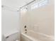 Simple bathroom featuring a white tub and shower combination with a window for natural light at 13832 Queenswater Ln, Charlotte, NC 28273