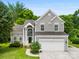 Charming two-story home with gray siding, arched entryway, and attached two-car garage at 13832 Queenswater Ln, Charlotte, NC 28273