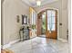 Elegant foyer featuring tile flooring, arched doorway, and natural light from the open wood doors at 1616 Indian Springs Nw Dr, Conover, NC 28613