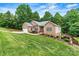 Brick home featuring a well-manicured lawn, an attached garage, and mature trees at 1616 Indian Springs Nw Dr, Conover, NC 28613