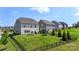 A spacious backyard featuring a black fence, lush green grass, and an area for outdoor relaxation under an umbrella at 17637 Snug Harbor Rd, Charlotte, NC 28278