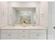 Bright bathroom featuring double sinks with white vanities, a large mirror, and a glass-enclosed shower at 17637 Snug Harbor Rd, Charlotte, NC 28278