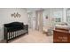 Bright Bedroom with a black crib, rocking chair, two windows, and neutral decor for a serene space at 17637 Snug Harbor Rd, Charlotte, NC 28278