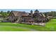 Luxurious clubhouse with outdoor patio, golf cart parking, and well-manicured lawn, creating a welcoming community atmosphere at 17637 Snug Harbor Rd, Charlotte, NC 28278