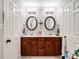 Well-lit bathroom featuring a double sink vanity, round mirrors, and modern fixtures at 1836 Fairlawn Ct, Rock Hill, SC 29732