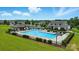 Aerial view of the community pool with lounge chairs and a clubhouse surrounded by lush green landscaping on a sunny day at 18619 Mainsail Ct, Lancaster, SC 29720