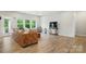 Cozy living room with a brown leather couch, hardwood floors, and large windows at 18619 Mainsail Ct, Lancaster, SC 29720