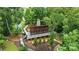 Elevated view of a cozy screened porch with stone chimney, nestled among trees and overlooking landscaped backyard at 18619 Mainsail Ct, Lancaster, SC 29720