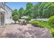 Landscaped backyard with a stone patio, outdoor furniture, manicured bushes, and a privacy fence at 18732 Coachmans Trce, Cornelius, NC 28031