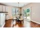 Bright breakfast nook with hardwood floors, glass table, sliding doors, and view of the backyard at 18732 Coachmans Trce, Cornelius, NC 28031