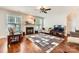 Cozy living room featuring a fireplace, ceiling fan, and large windows for ample natural light at 18732 Coachmans Trce, Cornelius, NC 28031