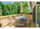 Back deck with umbrella table and chairs surrounded by mature trees and lush greenery at 2116 Eastway Dr, Charlotte, NC 28205
