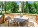 Outdoor dining space with umbrella table and decorative cast aluminum chairs on a wood deck at 2116 Eastway Dr, Charlotte, NC 28205