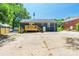 Rear exterior view with wood deck, dark siding, and concrete backyard space at 2116 Eastway Dr, Charlotte, NC 28205